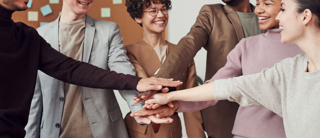 Happy workers huddle